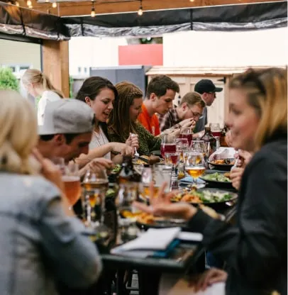 a group of people sitting around a table eating food